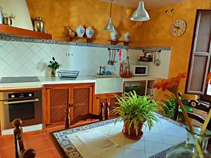 a kitchen with a table and a counter top at Casa Rural El Cencerro in Villamanrique de Tajo