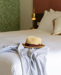 a hat sitting on top of a bed at Boutique Apartments Marsol Ibiza in Santa Eularia des Riu