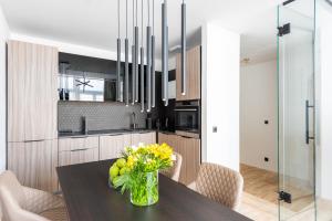 a kitchen with a table with a vase of flowers at Luxury apartment with a balcony and a terrace in Prague