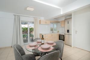 eine Küche und ein Esszimmer mit Tisch und Stühlen in der Unterkunft Livingstone Cottage by A&D Properties in Porto Rafti