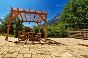 um gazebo de madeira com uma mesa e cadeiras num pátio em RTA Hotel Le Vallene em Terlago