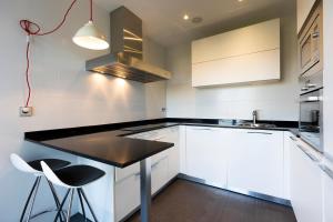 une cuisine avec des placards blancs et un comptoir noir dans l'établissement Villa Elisa by Basquelidays, à Fontarrabie
