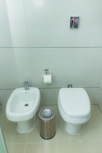 a bathroom with a white toilet and a sink at Awa Resort Hotel in Encarnación