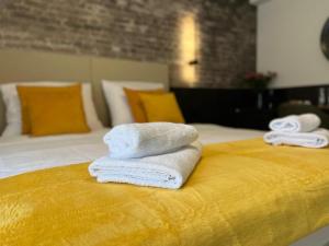 Dos toallas están apiladas encima de una cama. en Arena Prestige Rooms, en Pula