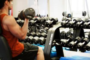 a man sitting in a gym lifting weights at Madrid Marriott Auditorium Hotel & Conference Center in Madrid