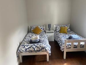 a bedroom with two beds with yellow pillows at Fort Mews in Ballina