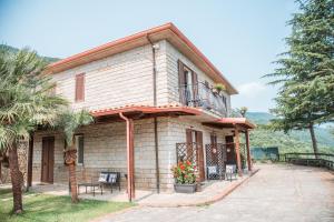 ein Haus mit einem Balkon und einer Palme in der Unterkunft Quattroemme Soc Agricola in Sinagra