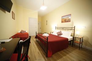 a bedroom with two beds and a desk in it at Al Quadrato D'Oro rooms in Catania