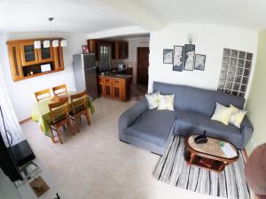 Vila Flor في Lajes das Flores: غرفة معيشة مع أريكة زرقاء ومطبخ
