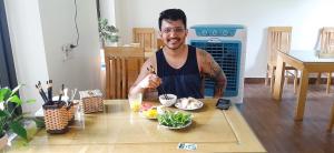 un hombre sentado en una mesa con un plato de comida en Tam Coc Golden Sky Homestay, en Ninh Binh