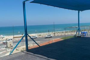 een uitzicht op het strand met een blauwe baldakijn bij 50 meters from the Sea, Ashkelon in Ashkelon