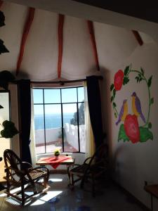 a room with a table and chairs and a window at Jardín Andino hostal in Copacabana
