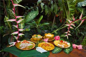 a table topped with lots of different types of food at Khao Sok Riverside Cottages in Khao Sok National Park