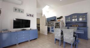 a kitchen with blue cabinets and a table with chairs at Conero Guest House in Numana