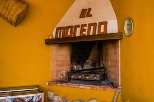 una chimenea de ladrillo con un reloj en una pared amarilla en Cueva de la tía Flor, en Castril
