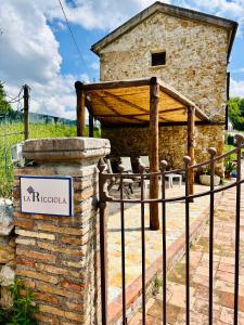 a stone building with a sign on a fence at La Riggiola in Salerno