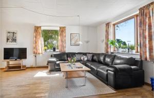 sala de estar con sofá de cuero negro y mesa en Awesome Home In Bandholm With 3 Bedrooms And Wifi, en Bandholm