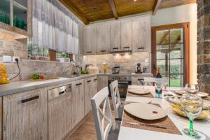 una cocina con armarios de madera, mesa y sillas en Chalet Perivoli, 