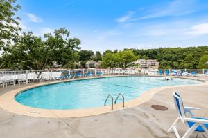 a large swimming pool with blue chairs in a resort at Regatta Retreat in Lake Ozark