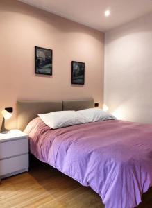 a bedroom with a purple bed with two pictures on the wall at Casa Pellico in Turin