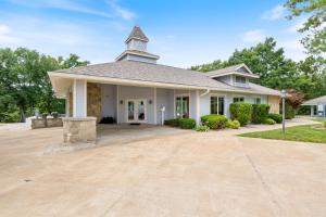 a home with a large driveway in front of a church at Regatta Retreat in Lake Ozark