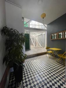une chambre avec un sol en damier, une table et une plante dans l'établissement Departamento Merced, à Quillota