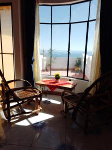 a room with a table and chairs and a large window at Jardín Andino hostal in Copacabana
