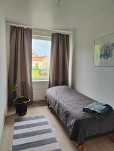 een slaapkamer met een bed voor een raam bij Two bedroom apartment close to city center in Jyväskylä