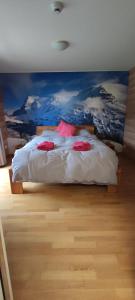 a bedroom with a bed with a painting on the wall at Hotel Restaurant Sonnenberg in Mürren