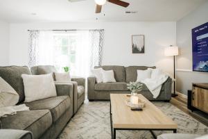 a living room with a couch and a table at Tranquil Luxury: Modern Comfort! in Lynchburg