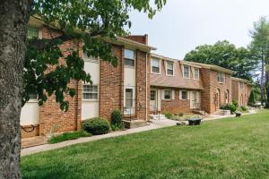 a brick building with a lawn in front of it at Tranquil Luxury: Modern Comfort! in Lynchburg