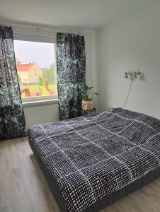 Un dormitorio con una cama grande y una ventana en Two bedroom apartment close to city center en Jyväskylä