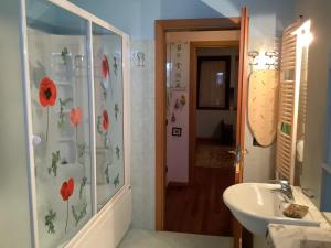 a bathroom with a sink and a shower with flowers on the wall at EDYSHOME in Peschiera del Garda