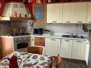 una cucina con armadi bianchi, tavolo e lavandino di EDYSHOME a Peschiera del Garda
