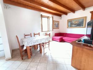 sala de estar con mesa y sofá rosa en Un passo dal mare e dalla città. en Cagliari