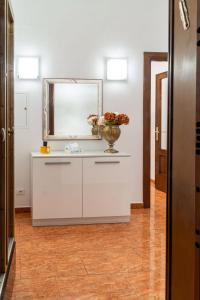 La salle de bains est pourvue d'un miroir et d'un vase avec des fleurs sur un comptoir. dans l'établissement La Maison D'Amelia, à Rome