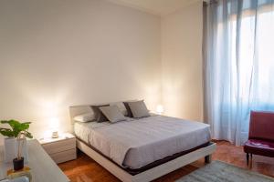 um quarto branco com uma cama e uma janela em La Maison D'Amelia em Roma