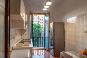 a kitchen with a sink and a large window at La Maison D'Amelia in Rome