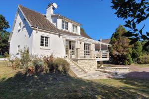 a white house with a porch and stairs at Casateja Houlgate in Houlgate