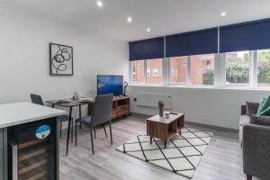 a living room with a table and a desk with a laptop at Fantastic 1 Bedroom Apartment in Preston in Preston