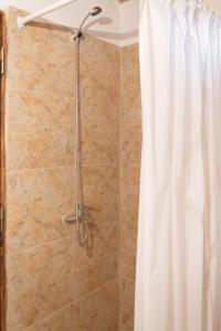 a shower with a white shower curtain in a bathroom at Monoambiente Golondrina in Capilla del Monte