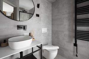 un baño con inodoro blanco y espejo en Arena Prestige Rooms, en Pula