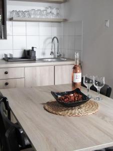 einen Tisch mit einer Schüssel Essen und zwei Weingläsern in der Unterkunft OBALA apartman in Subotica