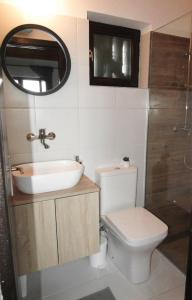 y baño con aseo, lavabo y espejo. en OBALA apartman en Subotica