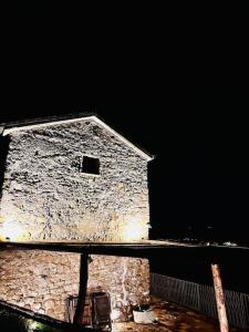 un antiguo edificio de piedra por la noche con un cielo oscuro en La Riggiola, en Salerno
