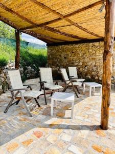 un grupo de sillas y mesas bajo un techo de madera en La Riggiola, en Salerno