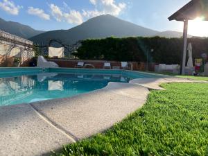 ein Schwimmbad in einem Garten mit Bergen im Hintergrund in der Unterkunft Villa Morena in Cava deʼ Tirreni