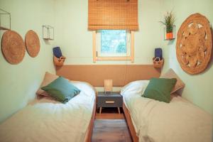 2 camas individuales en una habitación con ventana en Między drzewami, en Trupel