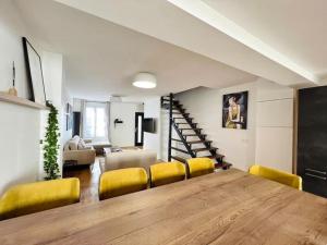 a dining room with a large wooden table and yellow chairs at House near Paris/Stade de France in Saint-Denis