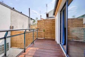 - un balcon d'une maison avec une clôture en bois dans l'établissement House near Paris/Stade de France, à Saint-Denis